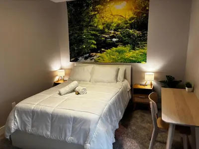 a bedroom with a bed with a painting on the wall at Nature Home Near Downtown and 17th Avenue in Calgary