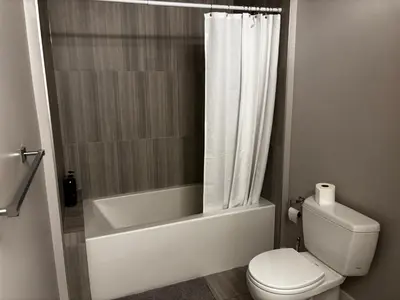 a bathroom with a tub and a toilet and a shower at Nature Home Near Downtown and 17th Avenue in Calgary