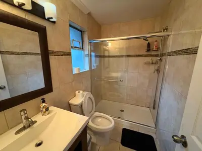 a bathroom with a shower and a toilet and a sink at North Delta Guest House - Scott Rd & Rapid Transit - Airport 20 Min - Free Parking & Fast Wi-Fi in Delta