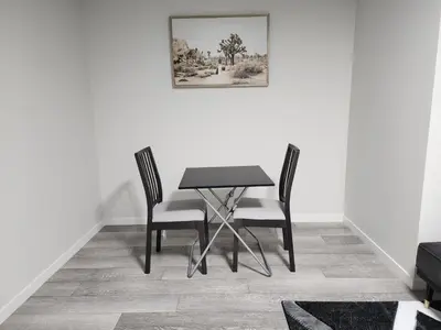 a dining room table with two chairs and a picture on the wall at Stylish furnished 2bedroom suite near YYC Airport in Calgary