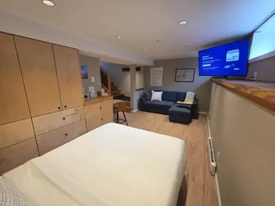 a room with a bed and a couch and a tv at NEW Midtown Rossland Studio Apartment in Rossland