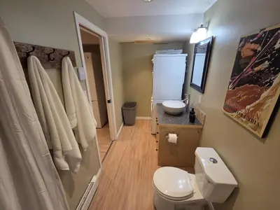 a bathroom with a white toilet and a sink at NEW Midtown Rossland Studio Apartment in Rossland