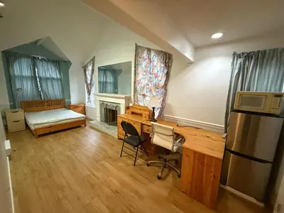 a living room with a desk and a microwave at EXTRA Large Suite with Ensuite Bathroom, Microwave & Fridge in Richmond