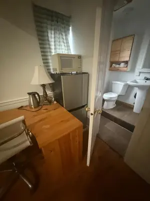 a small bathroom with a toilet and a table with a lamp at EXTRA Large Suite with Ensuite Bathroom, Microwave & Fridge in Richmond