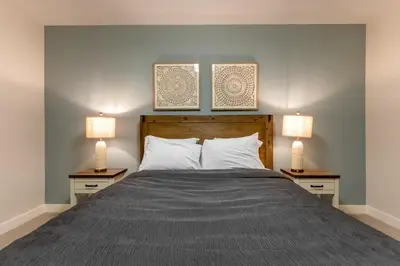 a bedroom with a bed with two lamps on two tables at Four Bears Chalet by Fernie Central Reservations in Fernie