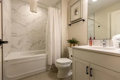 a bathroom with a toilet and a tub and a sink at Four Bears Chalet by Fernie Central Reservations in Fernie