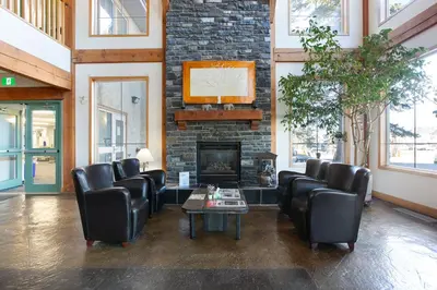 a lobby with leather chairs and a fireplace at Lakeview Inns & Suites - Okotoks in Okotoks