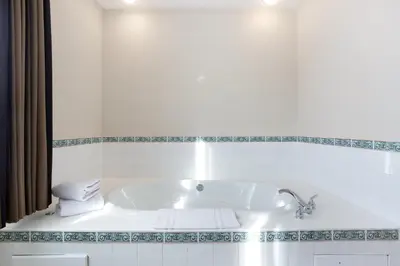 a white tub in a bathroom with a sink at Lakeview Inns & Suites - Okotoks in Okotoks