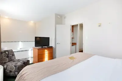 a hotel room with a bed and a television at Lakeview Inns & Suites - Okotoks in Okotoks