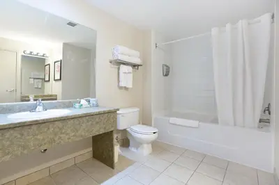 a bathroom with a sink and a toilet and a bath tub at Lakeview Inns & Suites - Okotoks in Okotoks