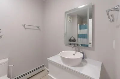 a white bathroom with a sink and a toilet at Comfort Tenacity in Yellowknife