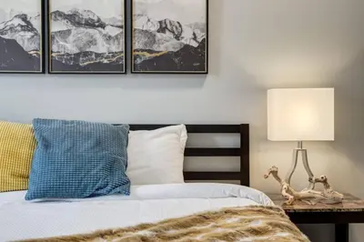 a bedroom with a bed and a table with a lamp at Stunning 3BR Escape with Mountain Views in Canmore in Canmore