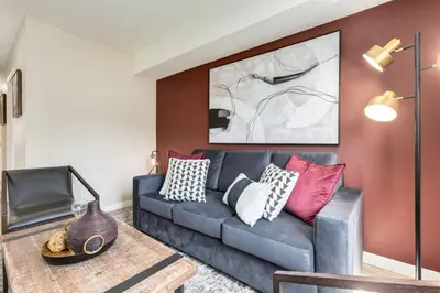 a living room with a blue couch with colorful pillows at Stylish 3BR Condo in DT Canmore in Canmore