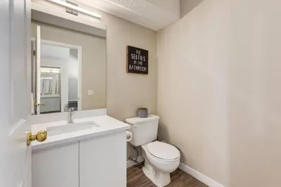 a bathroom with a toilet and a sink and a mirror at Stylish 3BR Condo in DT Canmore in Canmore
