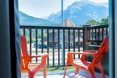 two chairs on a balcony with a view of a mountain at Stylish 3BR Condo in DT Canmore in Canmore