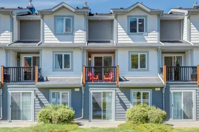 a row of houses with red chairs on the balcony at Stylish 3BR Condo in DT Canmore in Canmore