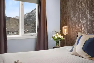 a bedroom with a bed and a window with a mountain at Great Rocky Mountain 3BR Condo in Canmore DT in Canmore