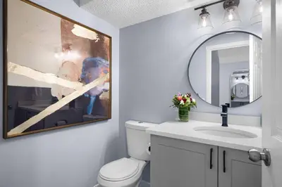 a bathroom with a toilet and a sink and a mirror at Great Rocky Mountain 3BR Condo in Canmore DT in Canmore