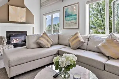 a living room with a couch and a fireplace at Rockies 3BR Townhome w Stunning Views Near DT in Canmore