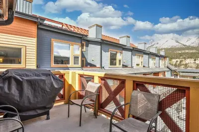 a balcony with chairs and a house with mountains at 3BR Luxury Top Floor Condo with Great views in Canmore