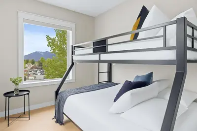 a bedroom with a bunk bed and a window at Newly Renovated 3BR Condo with Hot Tub and MTN Views in Canmore