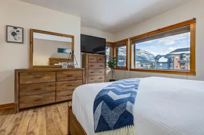 a bedroom with a bed and a dresser and a mirror at Spacious 3 BR Condo with Gym and Hot tub in Canmore