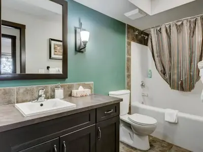 a bathroom with a sink and a toilet and a tub at Comfy 2BR Minutes from Downtown with Hot Tub in Dead Man's Flats