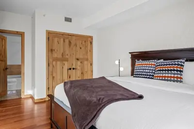 a bedroom with a large bed with a wooden headboard at Mountain Views Lux 2BR Condo in Canmore with Hot Tub in Canmore