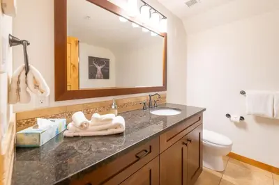 a bathroom with a sink and a mirror at Serene 3BR Rockies Stay with Hot Tub and Near DT in Canmore