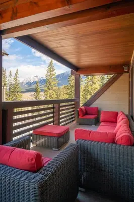 a balcony with couches and a view of a mountain at Serene 3BR Rockies Stay with Hot Tub and Near DT in Canmore