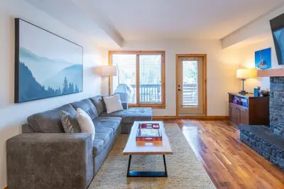 a living room with a couch and a table at Serene 3BR Rockies Stay with Hot Tub and Near DT in Canmore