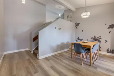 a dining room with a table and chairs and a staircase at Casablanca - 3 BR Family & Game Haven in Calgary