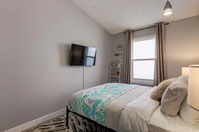 a bedroom with a bed and a flat screen tv at Casablanca - 3 BR Family & Game Haven in Calgary