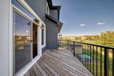 a balcony of a home with a large sliding glass door at Waterfront Home, Fireplace, 90 min to Banff in Airdrie