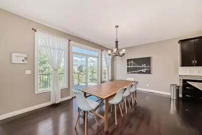 a dining room with a wooden table and chairs at Waterfront Home, Fireplace, 90 min to Banff in Airdrie