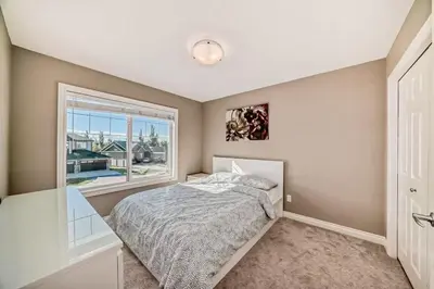 a bedroom with a bed and a window at Waterfront Home, Fireplace, 90 min to Banff in Airdrie