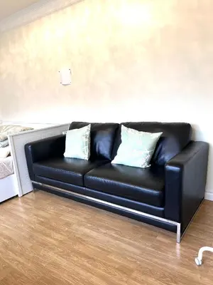 a black leather couch with two pillows in a room at Two Bedrooms One King Bed and One Double Bed in Richmond