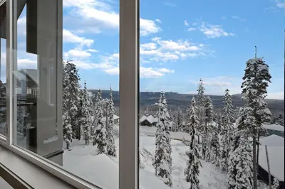 a view of a snowy forest from a window at Western Star Chalet Ski in out and Amazing Mtn View in Big White