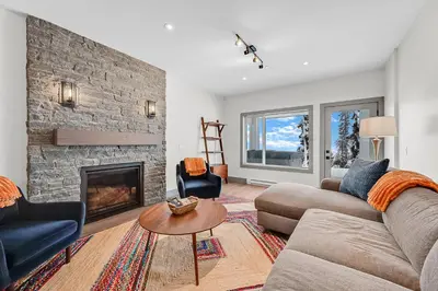 a living room with a couch and a fireplace at Western Star Chalet Ski in out and Amazing Mtn View in Big White