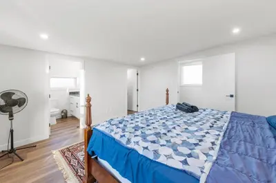 a bedroom with a bed with a blue comforter at Spacious Home • 3BR • Close to Whyte and Downtown in Edmonton