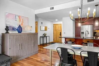 a kitchen and dining room with a table and chairs at Luxurious Condo Mountain Views Hot-tub and Billiards in Canmore