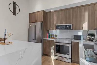 a kitchen with wooden cabinets and stainless steel appliances at Sisters' Solstice Villa by WeekAway Vacations in Canmore