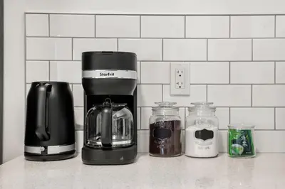 a kitchen counter with a coffeemaker and a coffee maker at Luxury Family Retreat with Games, King Bed and Garage in Edmonton