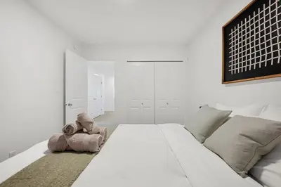 a teddy bear sitting on a bed in a bedroom at Luxury Family Retreat with Games, King Bed and Garage in Edmonton