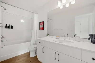 a white bathroom with a sink and a toilet at Luxury Family Retreat with Games, King Bed and Garage in Edmonton