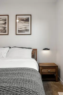 a bedroom with a bed and a nightstand and two pictures at Single Detached Full House with Ping Pong King Bed and Garage in Edmonton