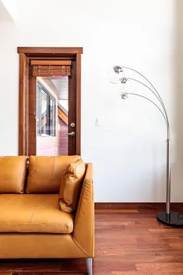 a brown couch in a living room with a lamp at El Paraiso - Luxury Downtown Penthouse in Canmore