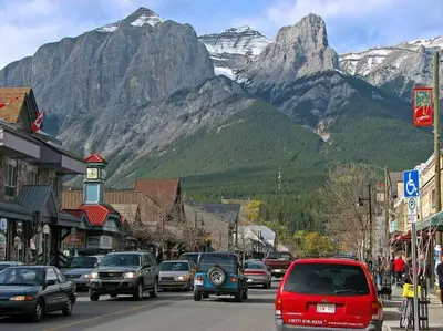 a busy street in a town with mountains in the background at El Paraiso - Luxury Downtown Penthouse in Canmore