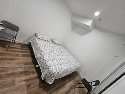 a bed in the corner of a room at Private room in Basement suite in Edmonton