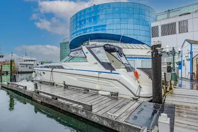 a boat docked at a dock in front of a building at COSY FLOATING HOME IN Vancouver downtown in Vancouver